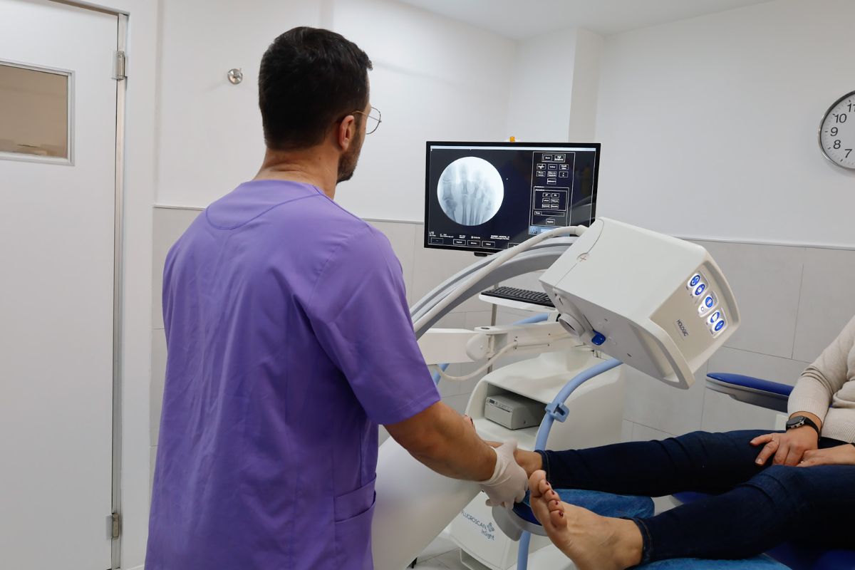 Podólogo realizando diagnóstico de juanetes con radiografía digital en clínica especializada